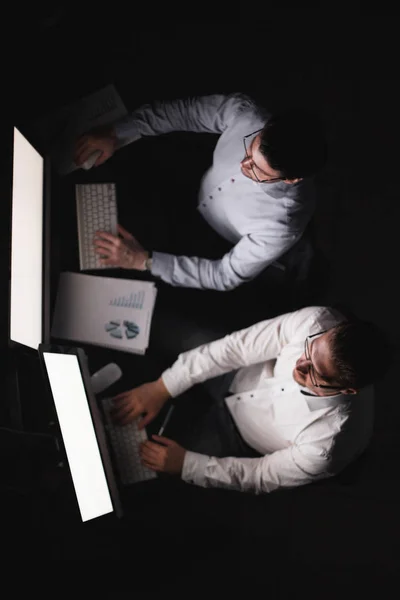 Dos hombres de negocios haciendo un informe financiero por la noche . — Foto de Stock