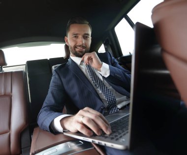 iş adamı arabaya otururken dizüstü bilgisayarda okur