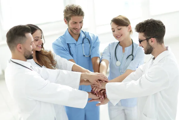Orvosok és nővérek egymásra rakják a kezüket. a kölcsönös segítségnyújtás fogalma. — Stock Fotó