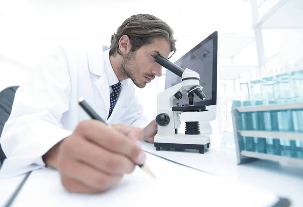 Científico hace una nota de experimento en el laboratorio —  Fotos de Stock