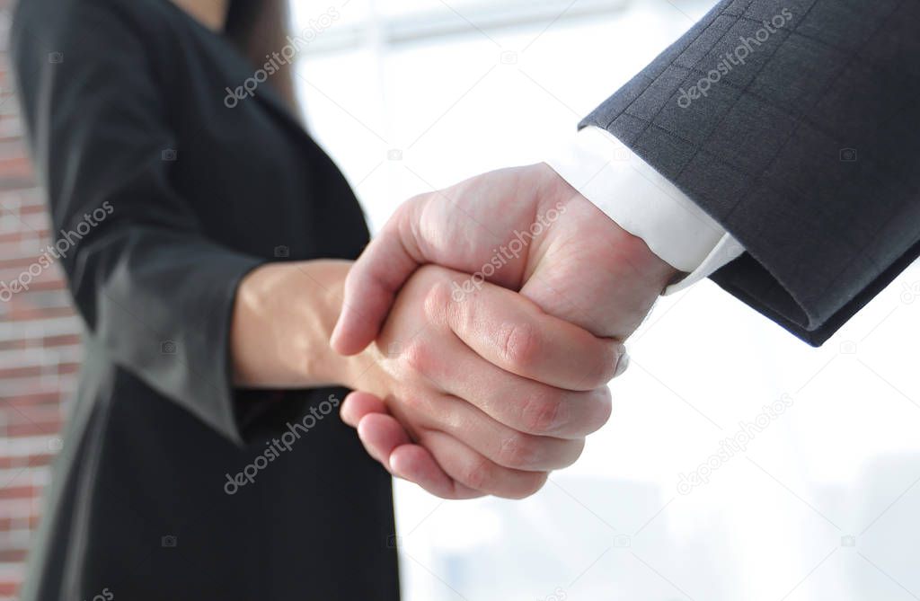 Close up of businessman and businesswoman shaking hands