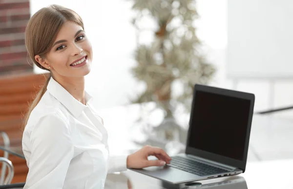 Junge Geschäftsfrau sitzt an ihrem Schreibtisch in einem Büro und arbeitet an einem Laptop — Stockfoto