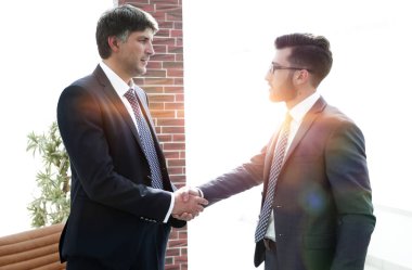 ofis koridorunda duran el sıkışan işadamları