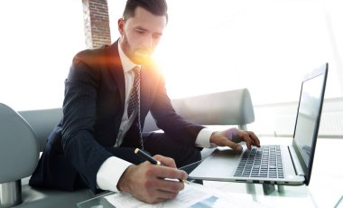 İş grafikleri ile bir dizüstü bilgisayar üzerinde çalışan iş adamı