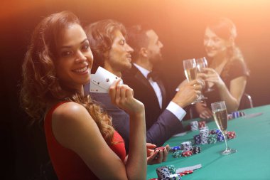 siyah arka plan üzerine poker oynamaya genç esmer kadın