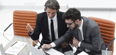 dizüstü bilgisayarda çalışan iki iş adamı