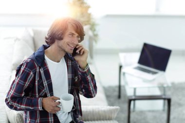 güzel bir fincan adamla bir dizüstü bilgisayar önünde oturur.