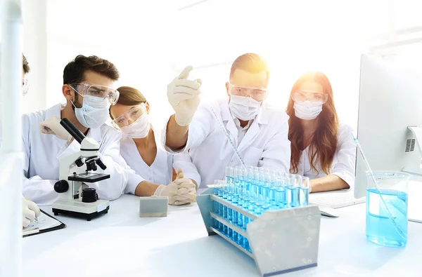 Médicos están trabajando con tubos de ensayo y microscopio en el laboratorio — Foto de Stock