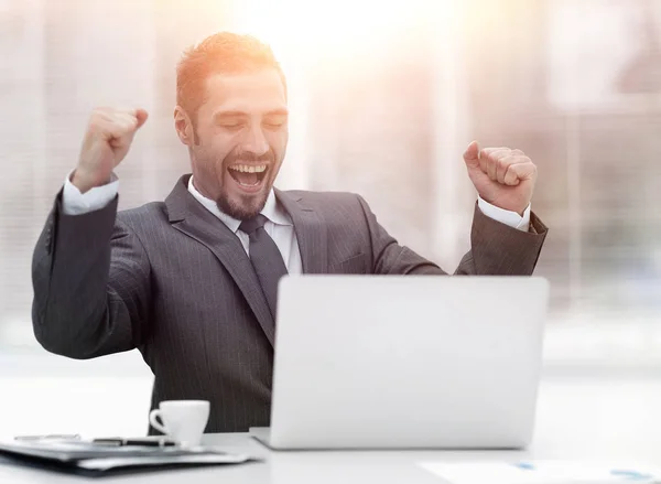 Closeup.Happy affärsman sitter framför en öppen laptop. — Stockfoto