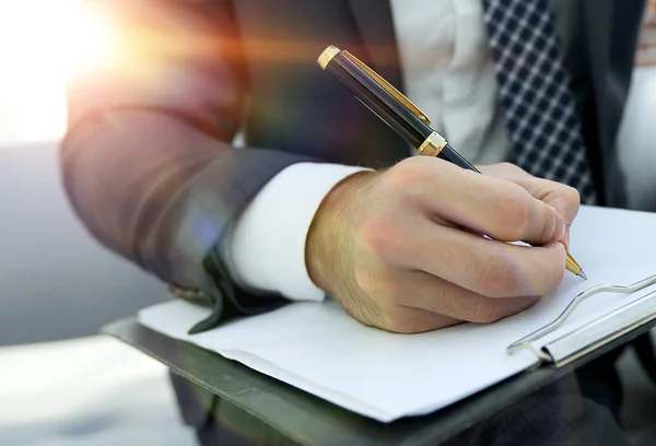 O empresário assina um contrato. Segurando a caneta na mão . — Fotografia de Stock