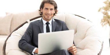 işadamı bir şık rahat chai oturan bir dizüstü bilgisayar ile