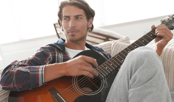 oturma odasında kanepede oturup gitar ile Modern adam.