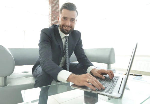 Homme qui travaille avec succès sur un ordinateur portable dans un bureau moderne — Photo