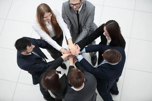 Fechar. alegre equipe de negócios com as mãos dobradas juntas — Fotografia de Stock