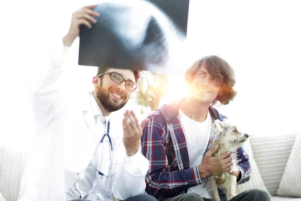 Veterinário mostrando um raio-x para o proprietário do cão . — Fotografia de Stock