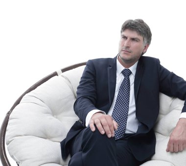 Başarılı bir iş adamı yumuşak bir rahat sandalyede oturur.