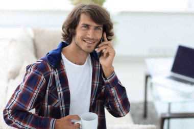 güzel bir fincan adamla bir dizüstü bilgisayar önünde oturur.