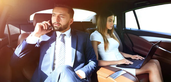 Üzletemberek használata mobiltelefonok és laptop utazás közben — Stock Fotó