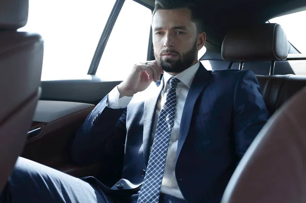 Uomo d'affari di successo seduto sul sedile posteriore di un'auto — Foto Stock