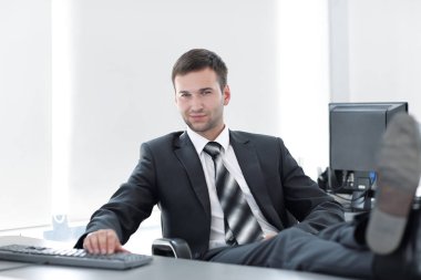 özel bir ofis masasında oturan kendine güvenen iş adamı