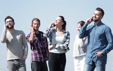 onların akıllı telefonlar üzerinde konuşurken öğrenci grubu.