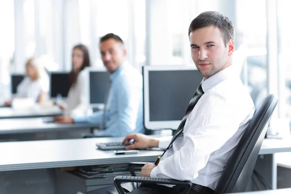 Porträt eines Mitarbeiters eines Unternehmens, der hinter einem Schreibtisch sitzt — Stockfoto