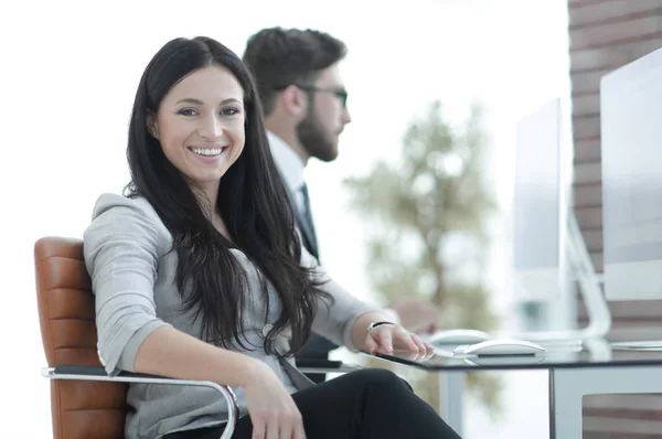Успішна усміхнена бізнес-леді сидить за столом — стокове фото