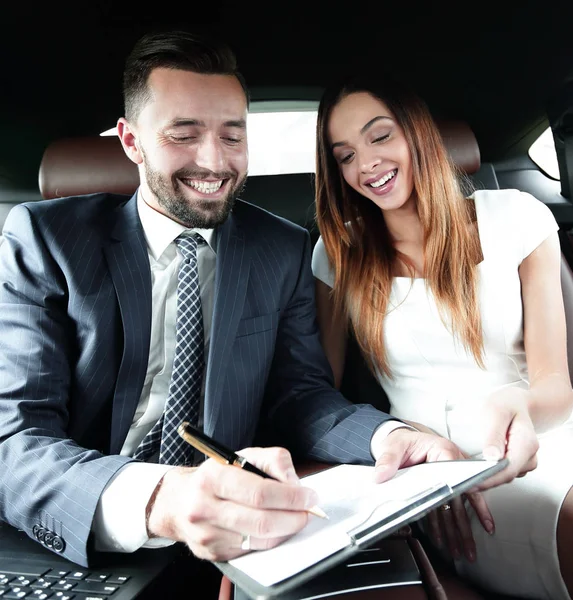 Mooie zakenvrouw werkt met een client in de auto — Stockfoto
