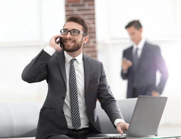 Jovem confiante falando por telefone no escritório — Fotografia de Stock