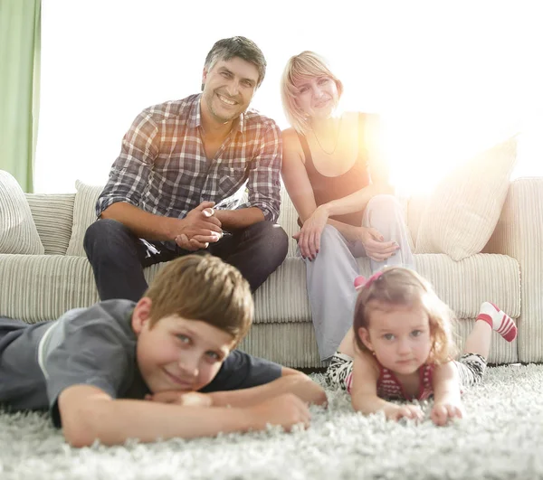 Portrait of happy family sitting together in living room — Stock Photo, Image