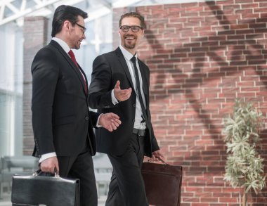 iki işadamı office koridorda yürürken gülümseyen