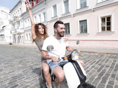 mutlu genç bir çift bir scooter üzerinde eğleniyor