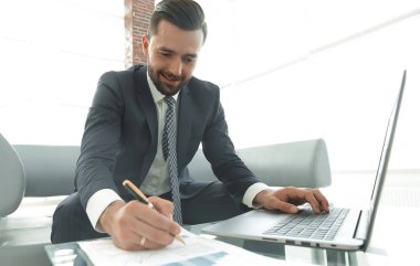 Dizüstü bilgisayarda çalışan ve Notlar not defterinde yapma şık adam