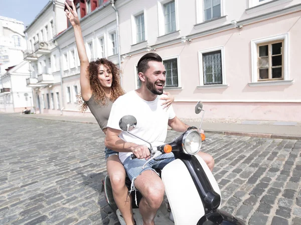mutlu genç bir çift bir scooter üzerinde eğleniyor