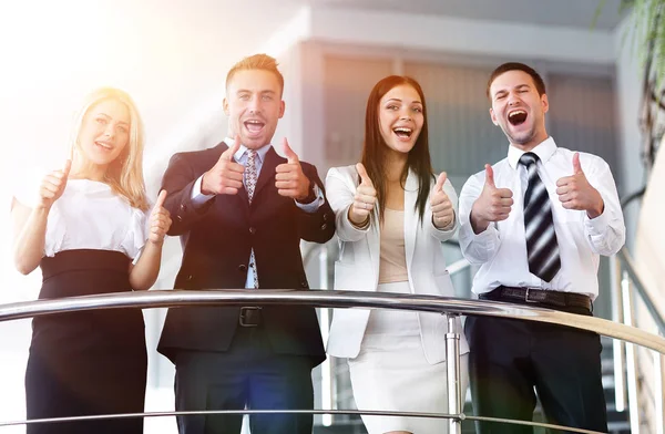 Equipo de negocios de pie en la terraza y muestra el pulgar hacia arriba . — Foto de Stock