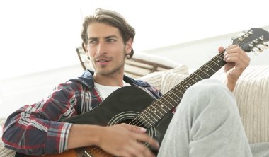 oturma odasında kanepede oturup gitar ile Modern adam.