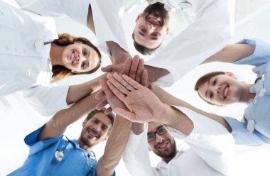 En alttaki görüntüde. Tıp merkezindeki bir grup doktor ellerini birbirine yapıştırdı.