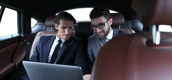 Two businessman talking while sitting in the car — Stock Photo, Image