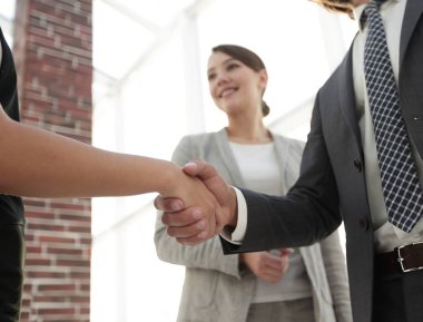 İş adamları geniş pencereli odaya karşı el sıkışıyor