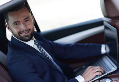 Otomatik olarak oturan dizüstü bilgisayar ile kendine güvenen iş adamı.