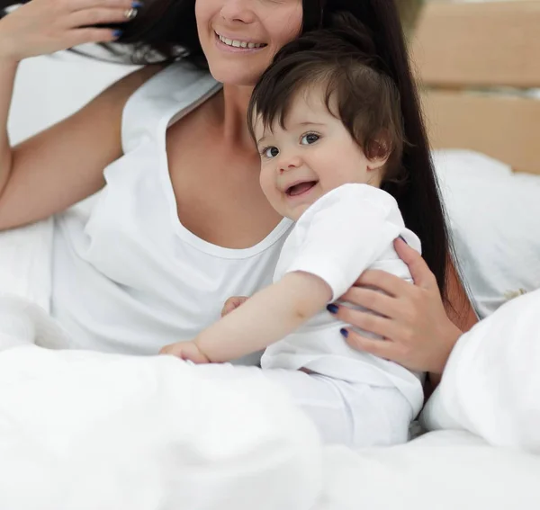 Güzel bir anne ile bebeği yatak odasında portresi — Stok fotoğraf