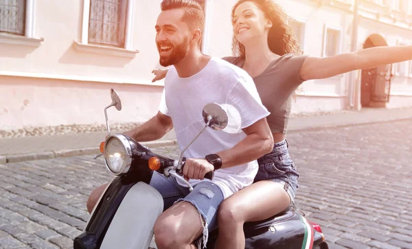 mutlu genç bir çift bir scooter üzerinde eğleniyor