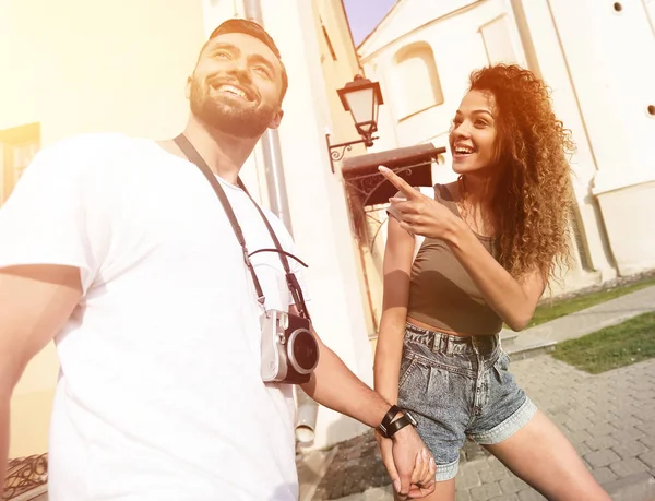 Bir çift şehrin sokaklarında yürüyor ve eğleniyor.