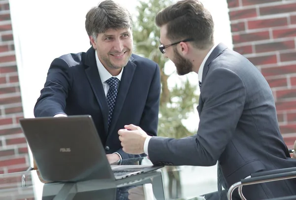 Dos hombres de negocios trabajando juntos usando el ordenador portátil en la reunión de negocios en la oficina — Foto de Stock