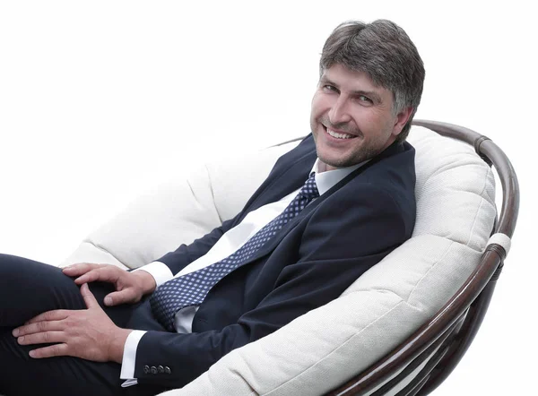 yan görünümü. Rahat koltuk kameraya bakarak oturan işadamı