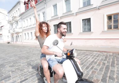 mutlu genç bir çift bir scooter üzerinde eğleniyor