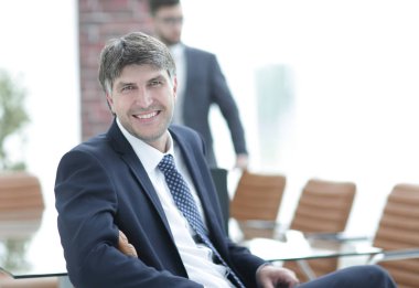 Bir boş toplantı odasında oturan işadamı