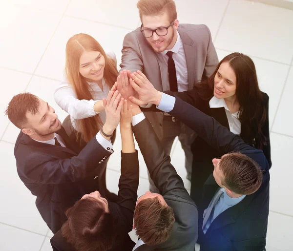 Fechar. alegre equipe de negócios com as mãos dobradas juntas — Fotografia de Stock