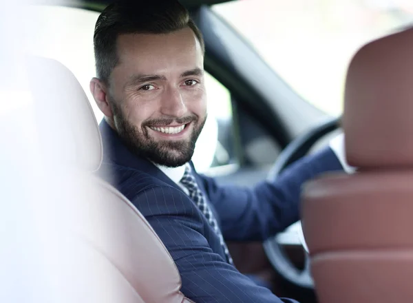Close-up of a businessman sitting at the wheel of a car — Stock Photo, Image