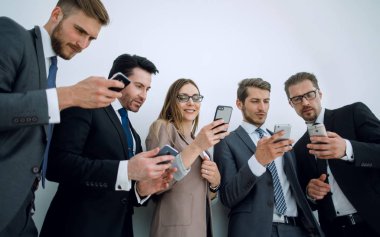 İş ekibi akıllı telefonlarının ekranlarına bakıyor.